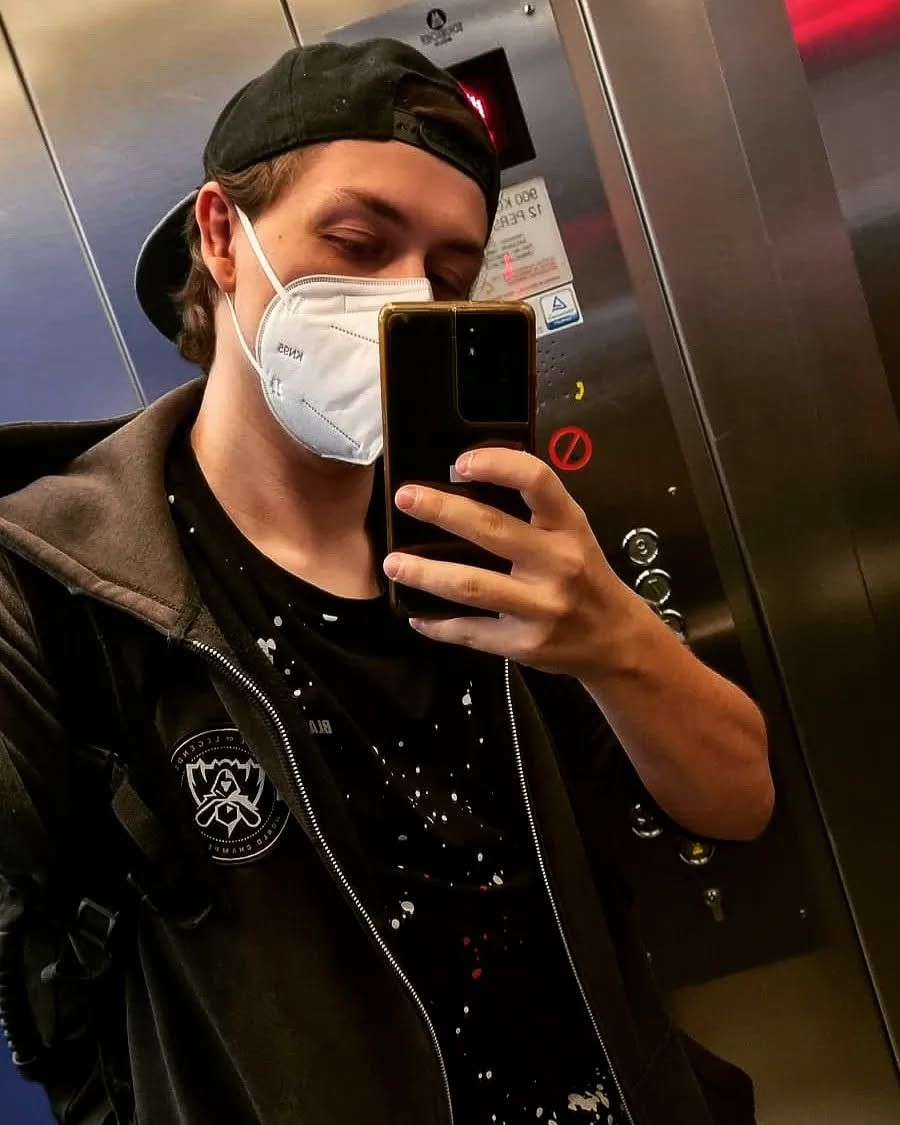 Spiegel-Selfie von t0g3pii in einem Aufzug, mit umgedrehter Cap und FFP2-Maske